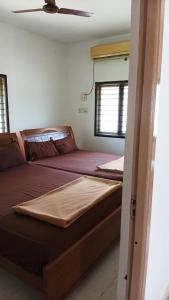 2 Betten in einem Zimmer mit einer Decke in der Unterkunft SRI SANKARA VILLAS -- Aditya Heritage in Kumbakonam
