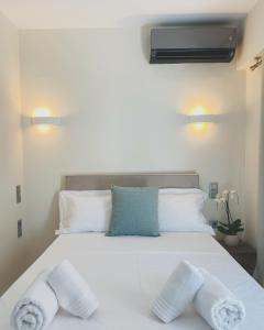 a bedroom with a white bed with towels on it at Cottage Boutique Apartments Athens in Athens +22 photos