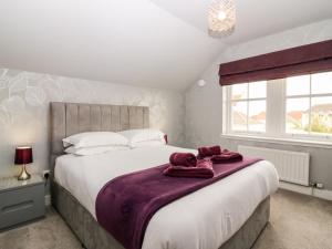 a bedroom with a large bed and a window at Glebe Cottage Number 6 in St Andrews