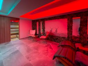 a room with red lighting and red chairs at Hotel Crystal - KitzHorn Suites in Sankt Johann in Tirol