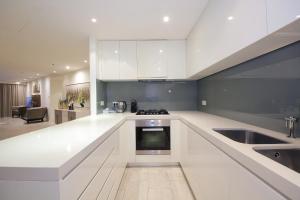 a large white kitchen with a sink and a stove at SHH - D1 Tower Apartments in Dubai