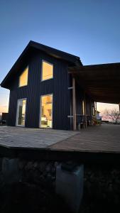 a black house with a porch and a wooden deck at Дом в горах Уютный дом с потрясающим видом и огромной террасой in Besqaynar