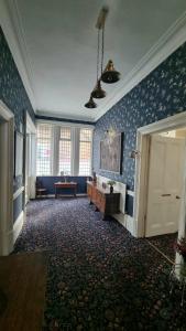 Habitación grande con papel pintado azul y puerta en The Cavendish, en Scarborough