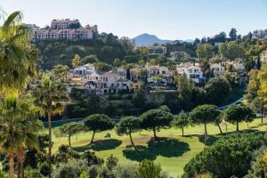 a view of a resort with palm trees and houses at Amazing Town House in La Quinta - Fantastic Views in San Pedro de Alcantara
