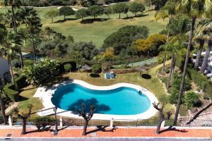 einen Blick über einen Pool in einem Garten mit Palmen in der Unterkunft Amazing Town House in La Quinta in San Pedro de Alcantara