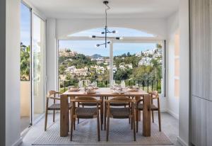 ein Esszimmer mit einem Tisch und Stühlen sowie einem großen Fenster in der Unterkunft Amazing Town House in La Quinta in San Pedro de Alcantara