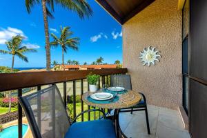 una mesa y sillas en un balcón con vistas al océano en Maui Vista 3411 condo, en Kihei