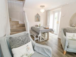 un salon avec une table et des chaises et un escalier dans l'établissement Honeysuckle Cottage Brailes, à Sutton under Brailes 19 autres photos