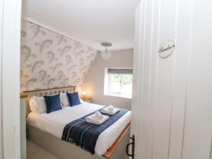 1 dormitorio con 1 cama con almohadas azules en Honeysuckle Cottage Brailes en Sutton under Brailes