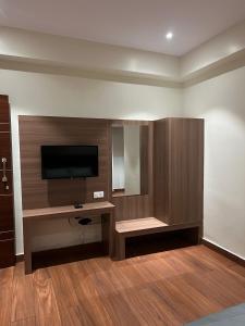 um quarto com uma televisão de ecrã plano na parede em Hotel Lakshmi Residency em Visakhapatnam
