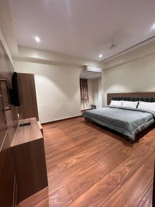 um quarto com uma cama e uma televisão de ecrã plano em Hotel Lakshmi Residency em Visakhapatnam