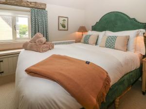 a bedroom with a large bed with towels on it at Spinners Cottage in Stow on the Wold