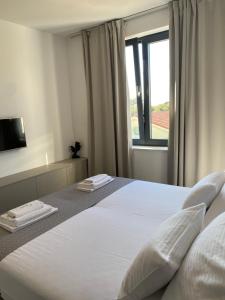 1 dormitorio con 1 cama blanca grande y ventana en Private Room Belmar Mandre, en Mandre