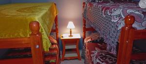 een slaapkamer met een bed en een tafel met een lamp bij Apartamentos El quincho in El Carmen
