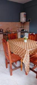 a kitchen with a table and chairs and a table and a sink at Apartamentos El quincho in El Carmen
