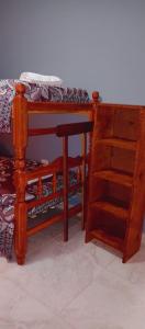a bedroom with a bed and a wooden book shelf at Apartamentos El quincho in El Carmen