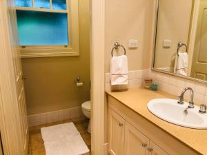W łazience znajduje się umywalka, toaleta i lustro. w obiekcie Lenore at Armidale w mieście Armidale