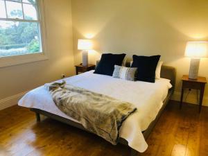 a bedroom with a large bed with two lamps at Lenore at Armidale in Armidale