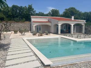 a villa with a swimming pool and a house at Hideaway Crikvenica with Sea view and Private Pool in Crikvenica