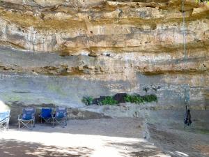 two blue chairs sitting in front of a rock wall at Hatter's Hideout Cave and Lodge in Newnes Junction