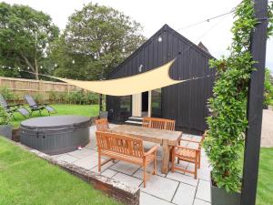 a patio with a table and chairs and a fire pit at Halcyon Barn, Wissett in Wissett