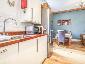 a kitchen with white cabinets and a sink at Hillcrest, Blythburgh in Blythburgh