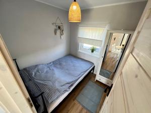 Kleines Zimmer mit einem Bett und einem Fenster in der Unterkunft Domki Maju Maj in Darłowo