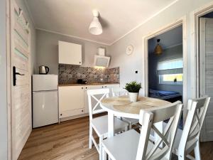 a kitchen and dining room with a table and chairs at Domki Maju Maj in Darłowo