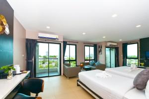 Bangkok NoiにあるNORN Rimkhlong Bangkok นอนริมคลองのベッド2台とリビングルームが備わるホテルルームです。