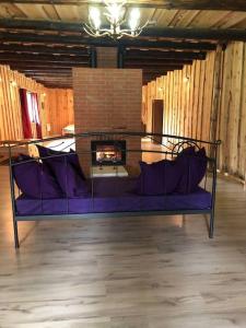 - un salon avec un canapé violet et une cheminée dans l'établissement The Barn, à Pärnu