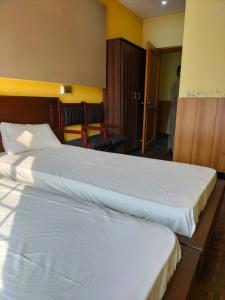 sypialnia z 2 łóżkami i drzwiami do pokoju w obiekcie Hotel Karma Muzaffarabad w mieście Muzaffarabad