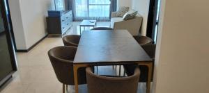 a dining room with a table and some brown chairs at Opus Residences Warisan Merdeka by C&C Fortune in Kuala Lumpur