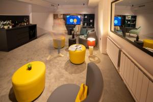 a waiting room with yellow stools and a bar at Maria Luisa by INTROVERT HOTELS in Sofia