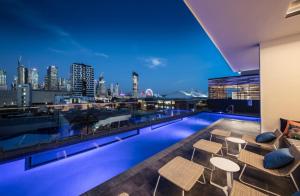 a rooftop pool with a view of the city at night at Elegant and Cozy Top Floor 1BD Apartment at South Bank in Brisbane