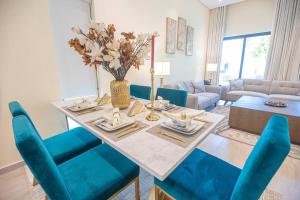 a living room with a table and blue chairs at Luxury 3 bdr Villa by the sea 54 in Fujairah