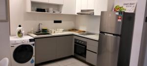 a small kitchen with a refrigerator and a dishwasher at Opus Residences Warisan Merdeka by C&C Fortune in Kuala Lumpur