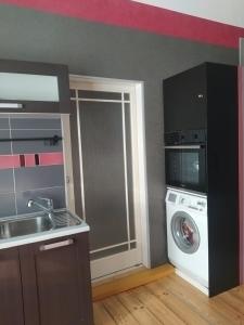 a kitchen with a washing machine and a washer at Julia Lacplesa Apartments in Riga