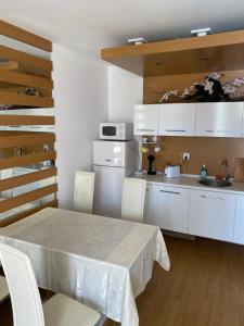 una cucina con un tavolo e mobili bianchi di Апартамент на солнечном берегу a Sunny Beach