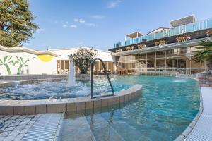 a swimming pool with a fountain in a building at Hotel Terme Patria in Abano Terme