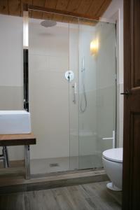 a glass shower in a bathroom with a sink and a toilet at Maison Rosina con ampia vista in borgo del 1400 in Marsciano