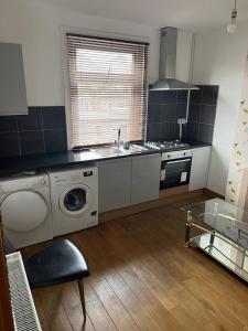 a kitchen with a sink and a washing machine at Home from Home in London