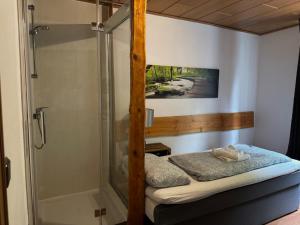 a small bedroom with a shower and a bed at Alte Ranch in Seesen