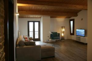 a living room with a couch and a tv at Maison Rosina con ampia vista in borgo del 1400 in Marsciano