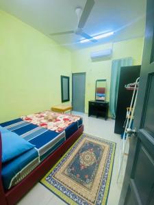 a bedroom with a bed and a rug in a room at Homestay Zalida C Musleem in Kampong Alor Gajah