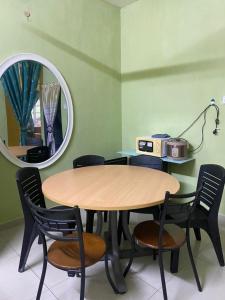 a table and chairs in a room with a mirror at Homestay Zalida C Musleem in Kampong Alor Gajah