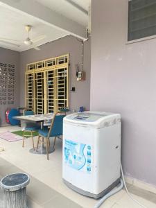 a room with a table and chairs and a heater at Homestay Zalida C Musleem in Kampong Alor Gajah