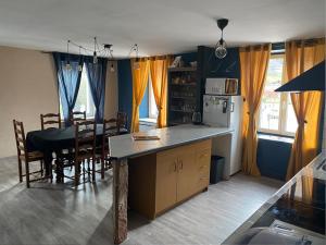 a kitchen and dining room with a table and a kitchen and a dining room at Appart 8 personnes le calice in Saint-Maurice-sur-Moselle