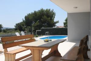 a patio with a table and chairs and a swimming pool at Villa Marta 3 bedrooms, 2 baths and pool in Kastel Stafilic