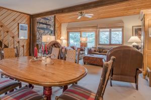 Sunburst Condo 2789 - Room for Up To 11 Guests and Elkhorn Resort Amenities في Elkhorn Village: غرفة معيشة مع طاولة وكراسي خشبية