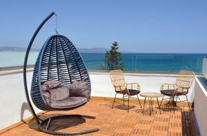 a swing on the roof of a house with chairs at Atlantis Hotel in Kos